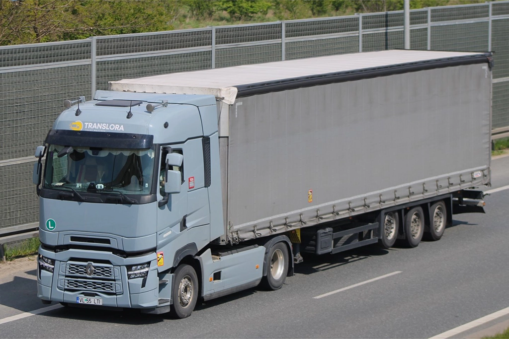 Camion Renault modern si semiremorca cu prelata fotografiate pe autostrada
